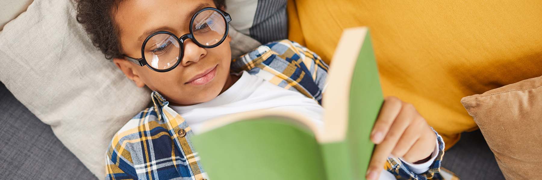 A child laying down and reading a book