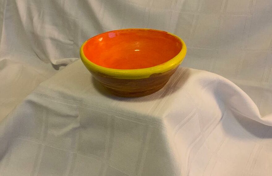 A picture of a bowl painted in a sunrise color scheme. 