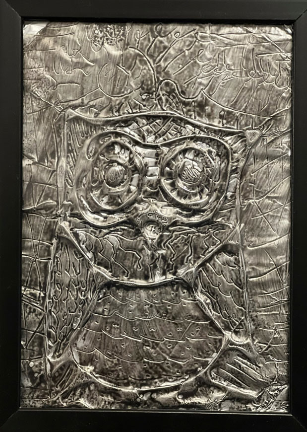 A child's foil art piece of an owl.