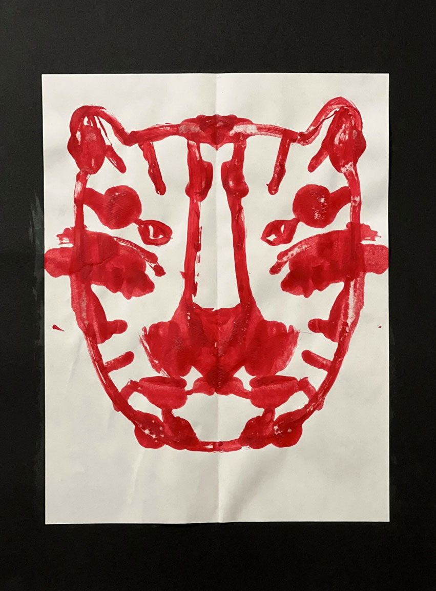 A painting of a tiger in red on a white piece of paper.