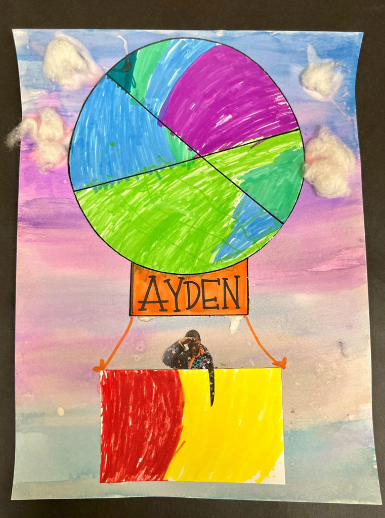 A multicolored hot air balloon art piece with a picture of a child in its basket, on top of a blue, pink and purple gradient background.