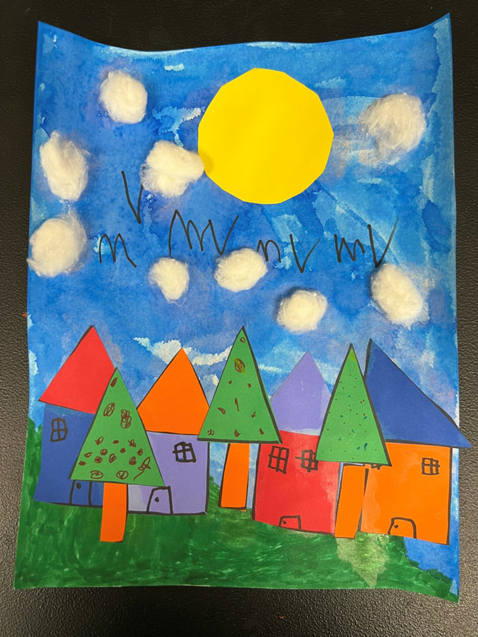 An artwork of cut out primary and secondary colored houses on a blue sky and green grass background.
