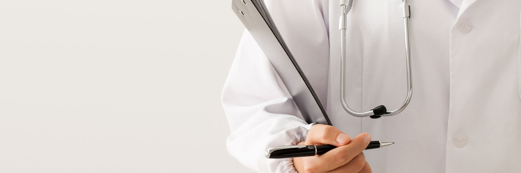 A doctor in a lab coat holding a clipboard and pen